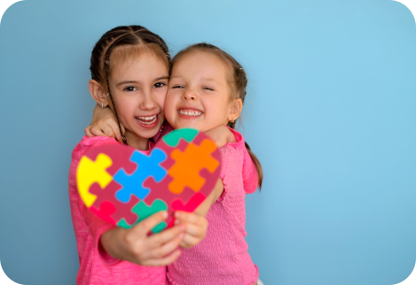 two girls hugging and holding a heart puzzle